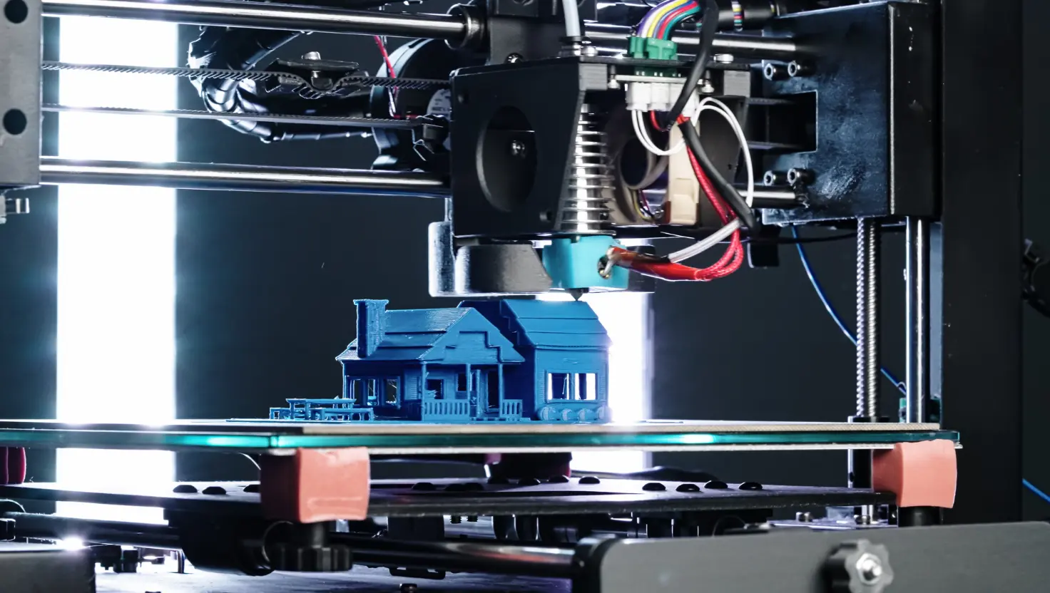 3D printer die een blauw huismodel print